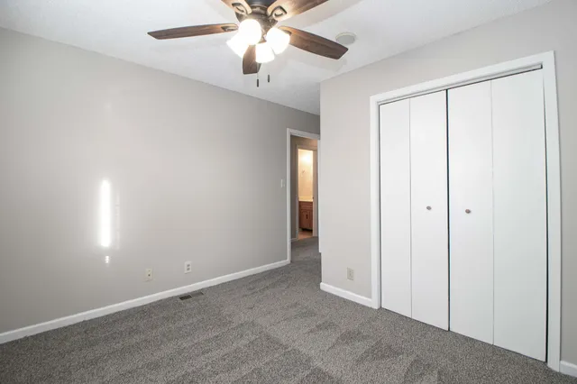 an empty room with a window and a fan