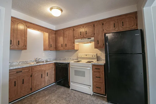 a kitchen with a refrigerator sink and cabinets