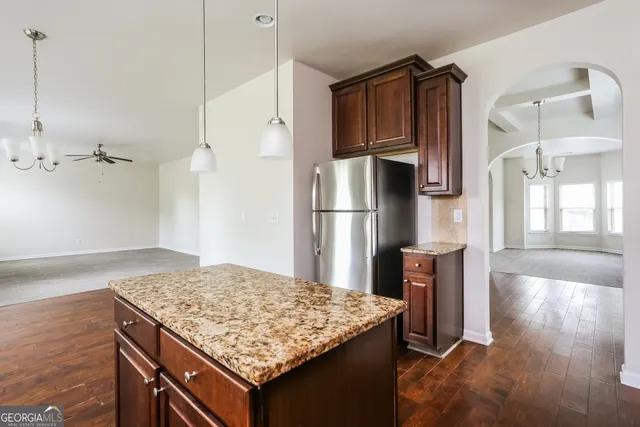 a kitchen with kitchen island a refrigerator sink and wooden floor