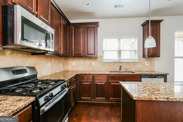 a kitchen with granite countertop a stove and a sink