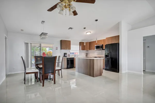 a view of a dining room with furniture and a kitchen