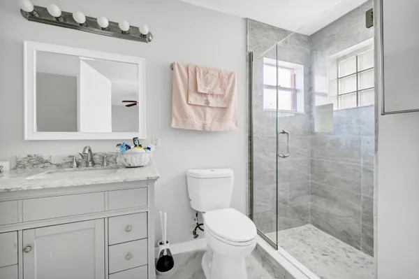 a bathroom with a granite countertop sink toilet and shower