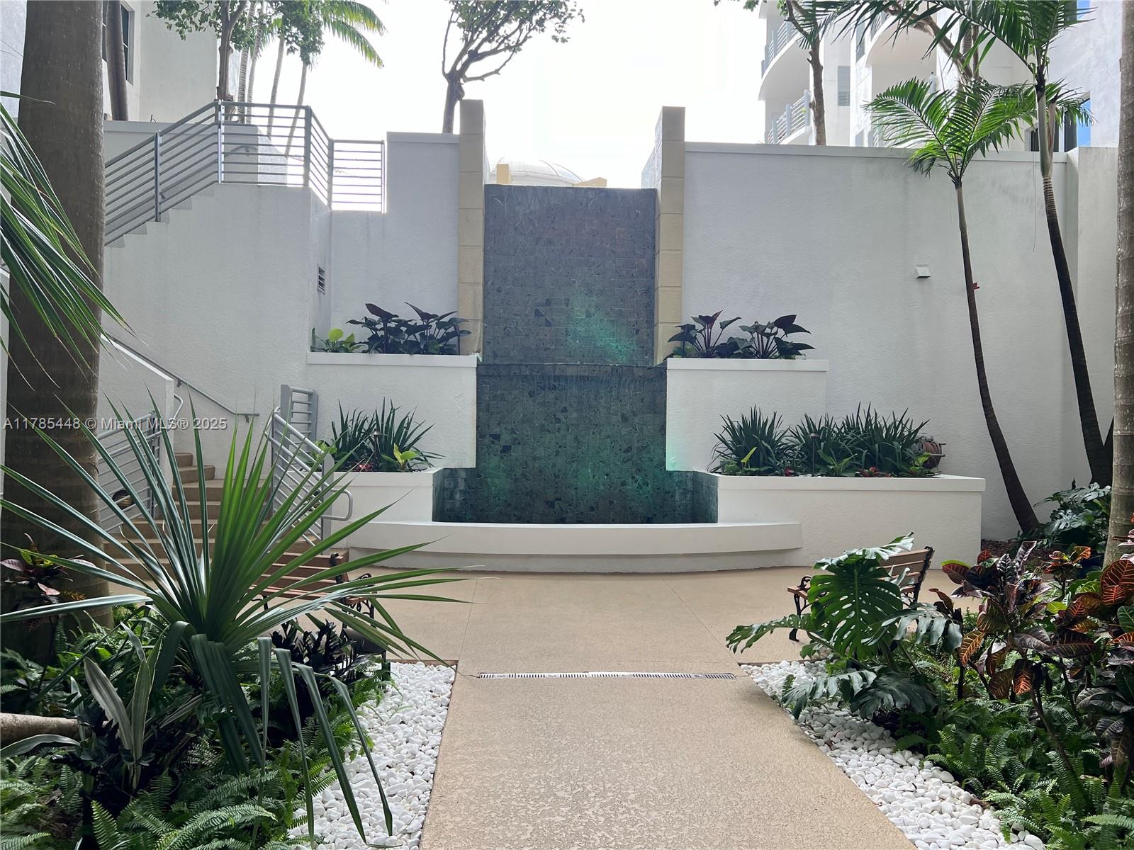 1830 Radius Drive, Unit 909 Hollywood, FL 33020 - Photo 20 of 22 a view of a house with a yard and potted plants