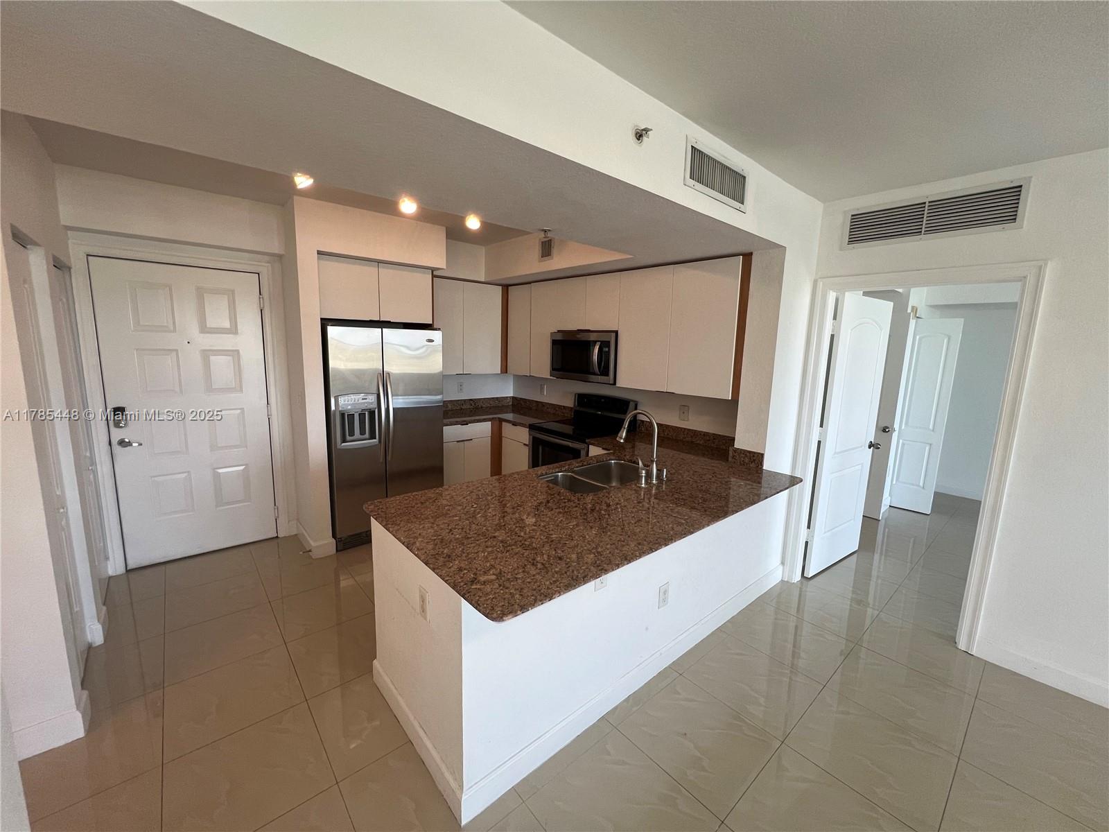 1830 Radius Drive, Unit 909 Hollywood, FL 33020 - Photo 2 of 22 a kitchen with stainless steel appliances granite countertop a sink a refrigerator and a granite counter tops