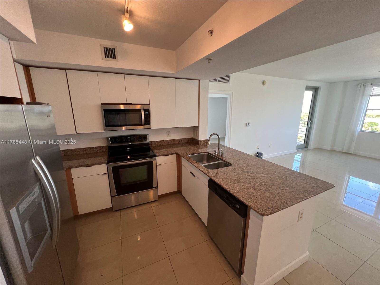 1830 Radius Drive, Unit 909 Hollywood, FL 33020 - Photo 3 of 22 a kitchen with stainless steel appliances granite countertop a sink stove and refrigerator