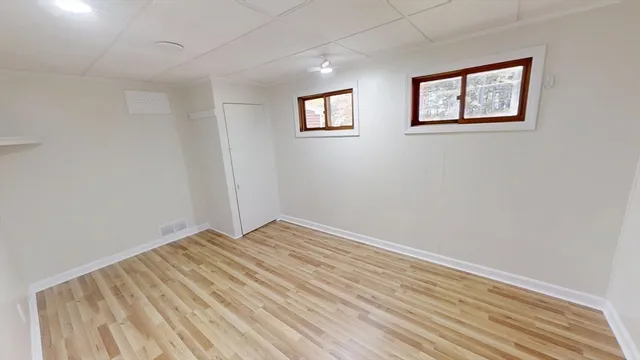 an empty room with windows and closet