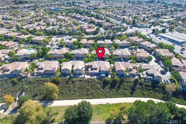 an aerial view of residential houses with outdoor space and trees