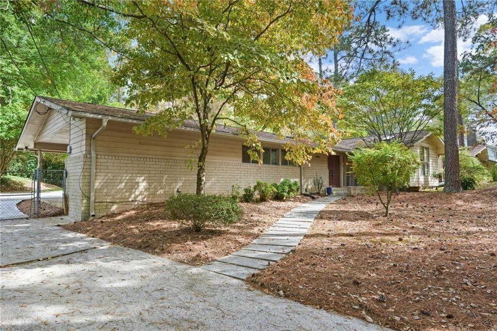705 Edgewater Trail Sandy Springs, GA 30328 - Photo 1 of 36 a backyard of a house with large trees and outdoor seating