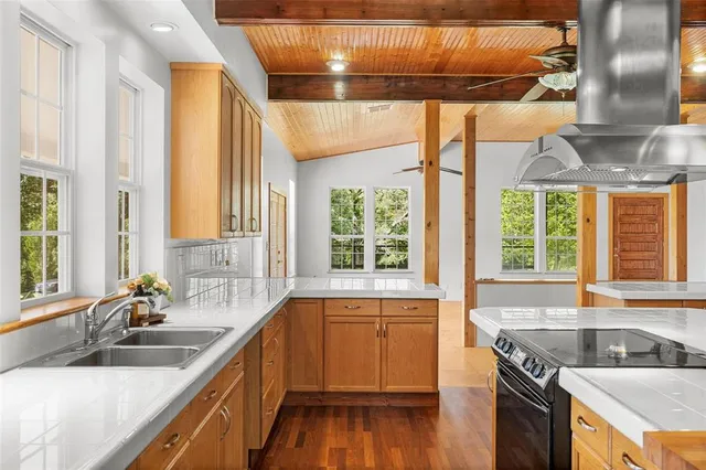 a kitchen with a sink a counter top space and stainless steel appliances