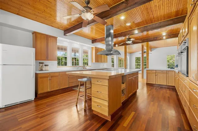 a kitchen with a refrigerator a sink and wooden floor