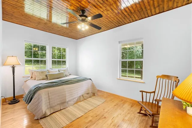 an empty room with ceiling fan and windows