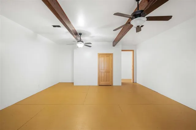 an empty room with a ceiling fan and window