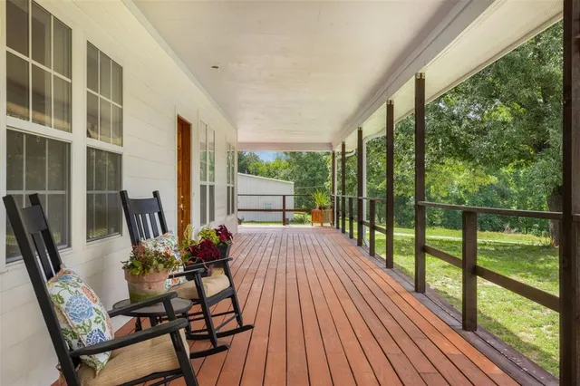 a view of a balcony with chairs and wooden floor