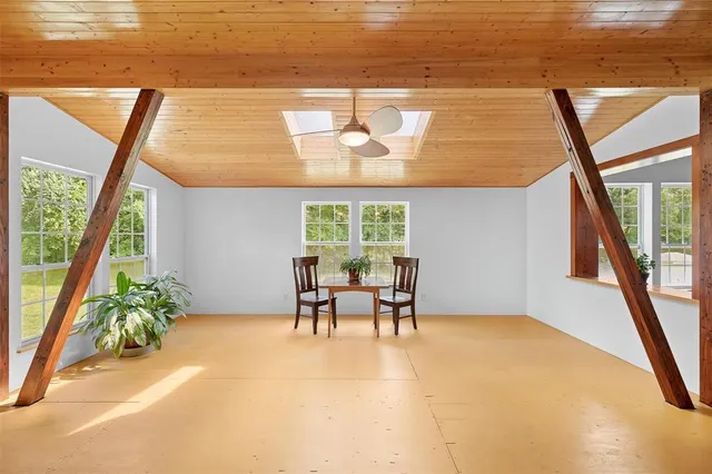 a dining room with furniture and a large window