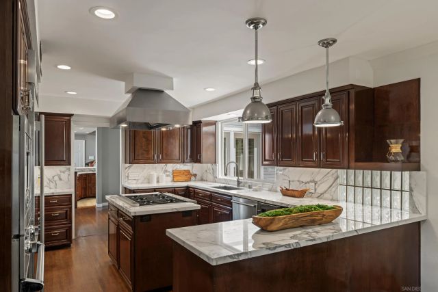 a kitchen with a stove a sink a window and wooden floor