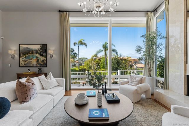 a living room with fireplace furniture and a large window
