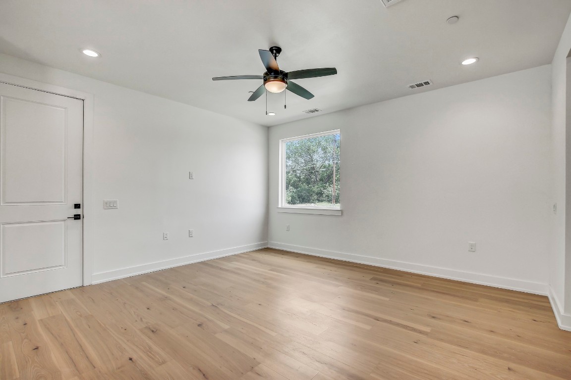 4127 East 12th Street, Unit 5 Austin, TX 78721 - Photo 11 of 33 Unfurnished room with ceiling fan, light wood-type flooring, baseboards, and recessed lighting