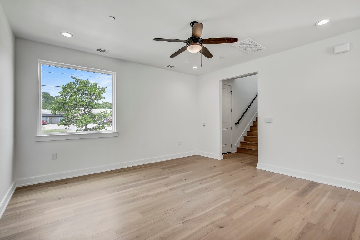 4127 East 12th Street, Unit 5 Austin, TX 78721 - Photo 12 of 33 Spare room featuring a ceiling fan, baseboards, light wood-type flooring, stairway, and recessed lighting
