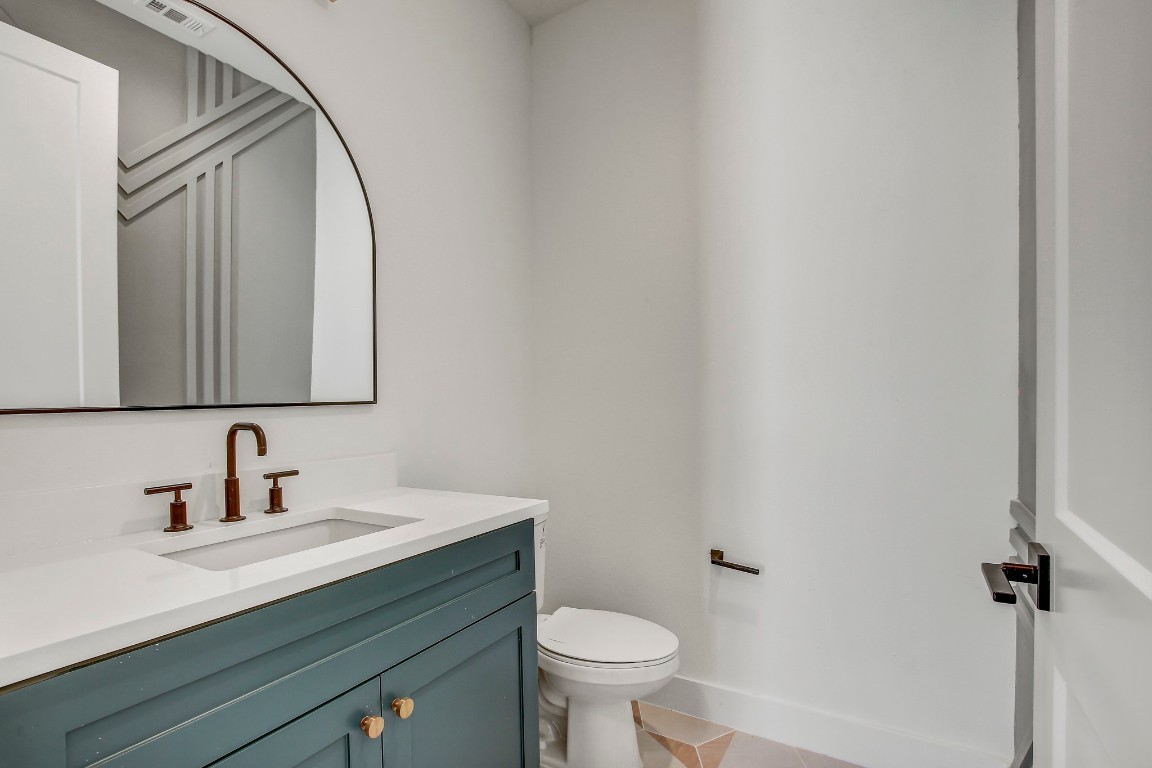 4127 East 12th Street, Unit 5 Austin, TX 78721 - Photo 15 of 33 Half bathroom with vanity, toilet, and tile patterned flooring