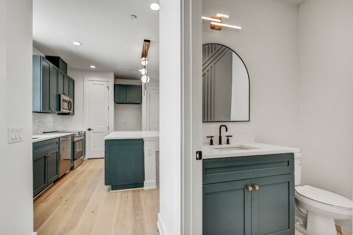 4127 East 12th Street, Unit 5 Austin, TX 78721 - Photo 16 of 33 Full bath featuring two vanities, wood finished floors, recessed lighting, toilet, and tasteful backsplash