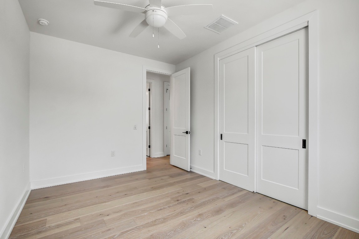 4127 East 12th Street, Unit 5 Austin, TX 78721 - Photo 24 of 33 Unfurnished bedroom with light wood-type flooring, a closet, baseboards, and ceiling fan