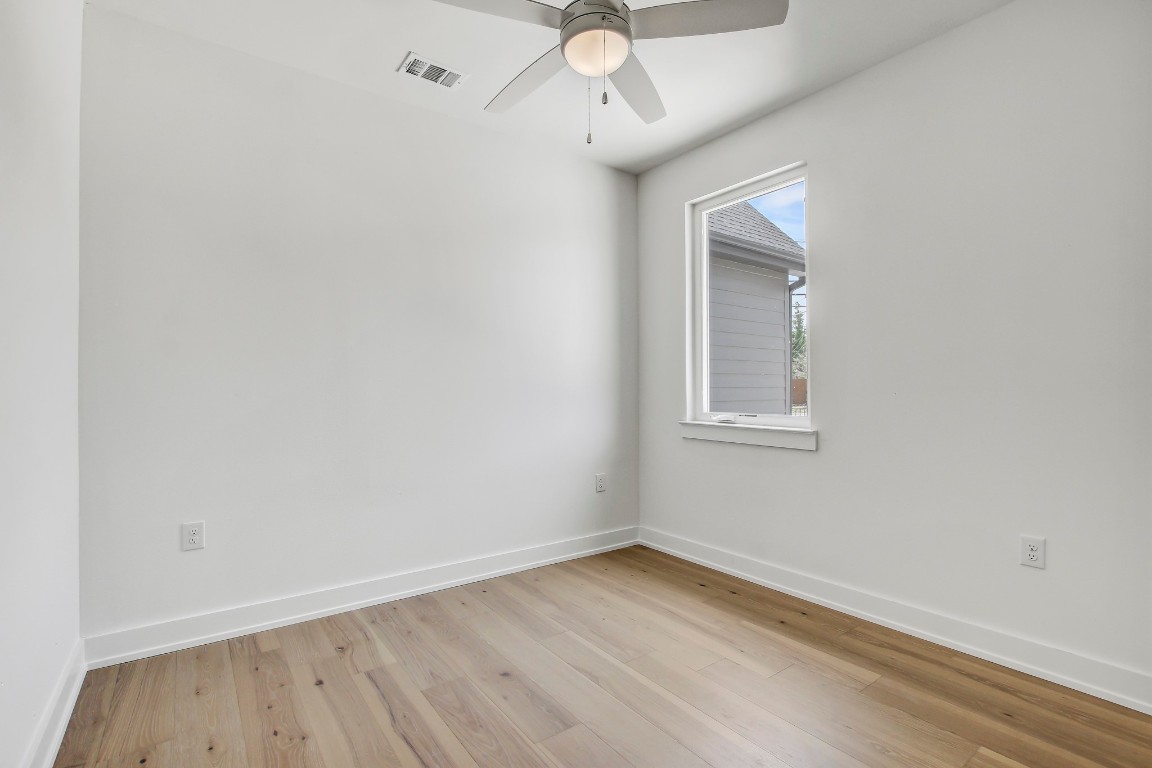 4127 East 12th Street, Unit 5 Austin, TX 78721 - Photo 26 of 33 Empty room with light wood-style floors, ceiling fan, and baseboards