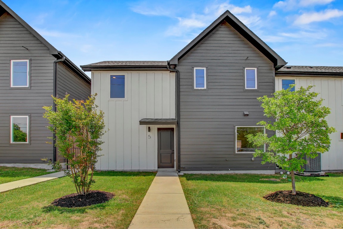 4127 East 12th Street, Unit 5 Austin, TX 78721 - Photo 31 of 33 View of front facade with board and batten siding and a front yard
