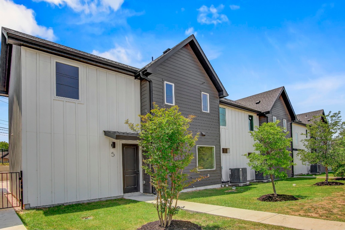 4127 East 12th Street, Unit 5 Austin, TX 78721 - Photo 32 of 33 View of front of property featuring board and batten siding, central AC, and a front lawn
