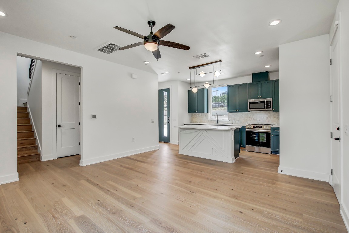 4127 East 12th Street, Unit 5 Austin, TX 78721 - Photo 5 of 33 Kitchen with appliances with stainless steel finishes, light countertops, a ceiling fan, tasteful backsplash, and recessed lighting