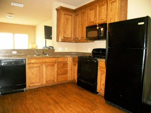 a kitchen with stainless steel appliances granite countertop a refrigerator and a stove top oven