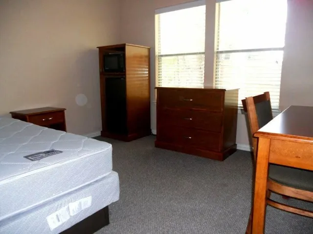 a room with a window and a dresser