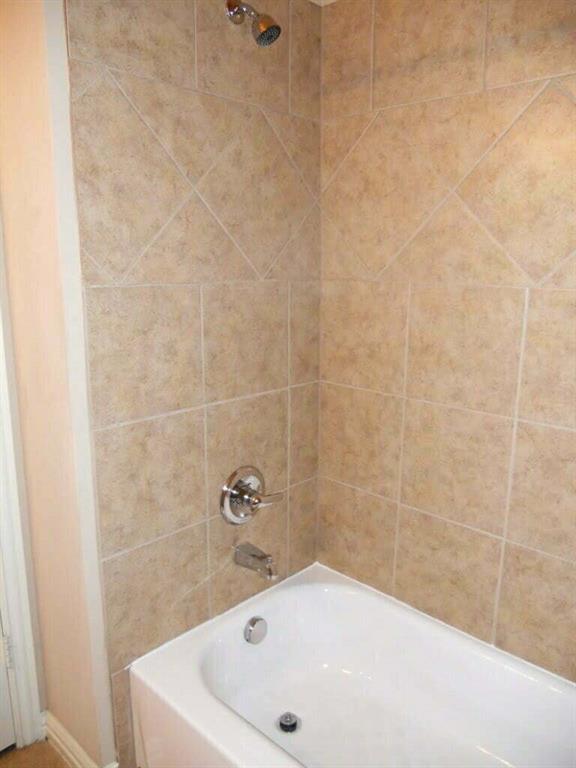 2418 West Prairie Street, Unit 1 Denton, TX 76201 - Photo 9 of 11 a bathroom with a white tub