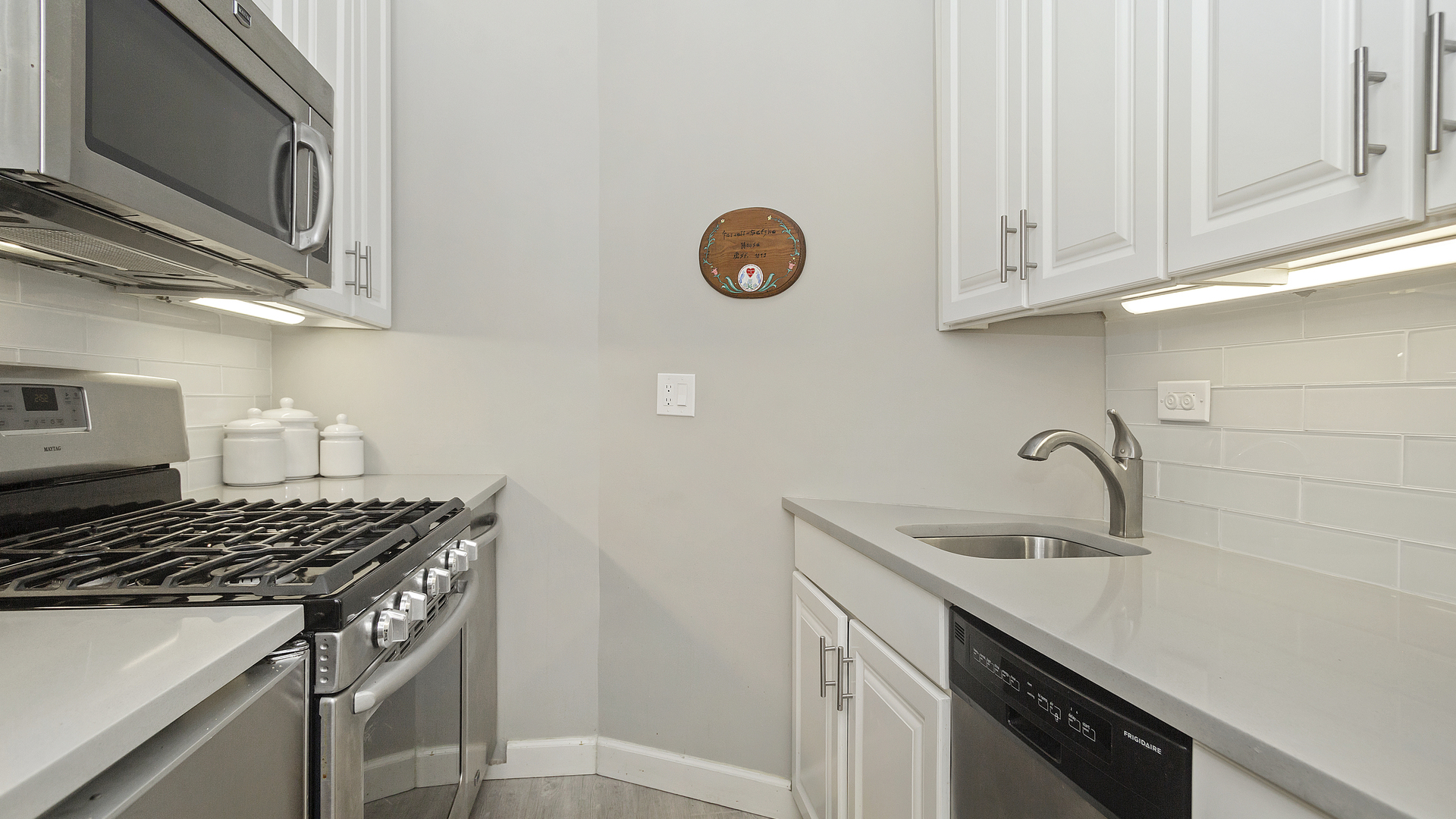 70 East Scott Street, Unit 908 Chicago, IL 60610 - Photo 12 of 15 a kitchen with granite countertop a sink stainless steel appliances and cabinets