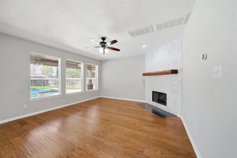 a view of an empty room with a fireplace and a window