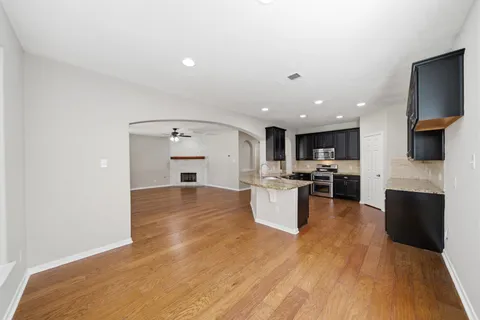 a view of kitchen with microwave a refrigerator and wooden floor