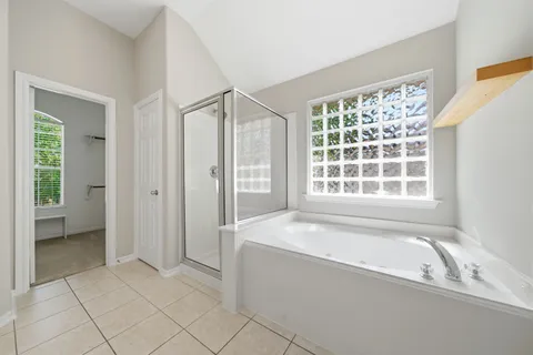 a spacious bathroom with a granite countertop sink a toilet a mirror and shower
