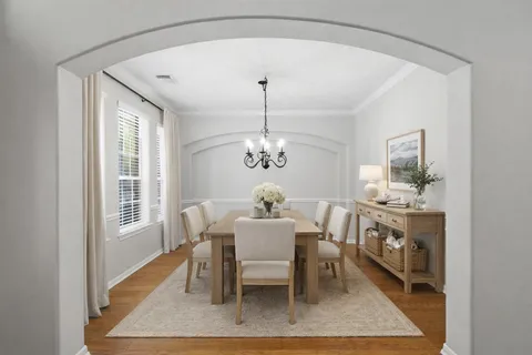 a dining room with furniture a rug and a chandelier