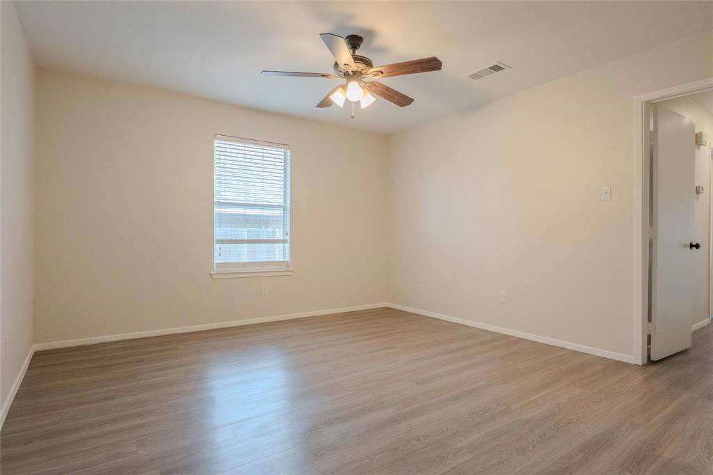 527 Crowley Road Arlington, TX 76012 - Photo 15 of 20 an empty room with wooden floor chandelier fan and windows