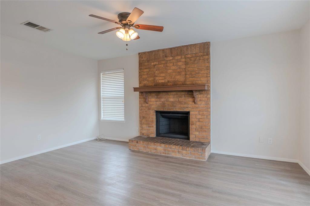 527 Crowley Road Arlington, TX 76012 - Photo 9 of 20 a view of a livingroom with a fireplace a chandelier fan and wooden floor