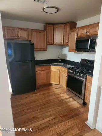 a kitchen with granite countertop wooden cabinets and a stove top oven