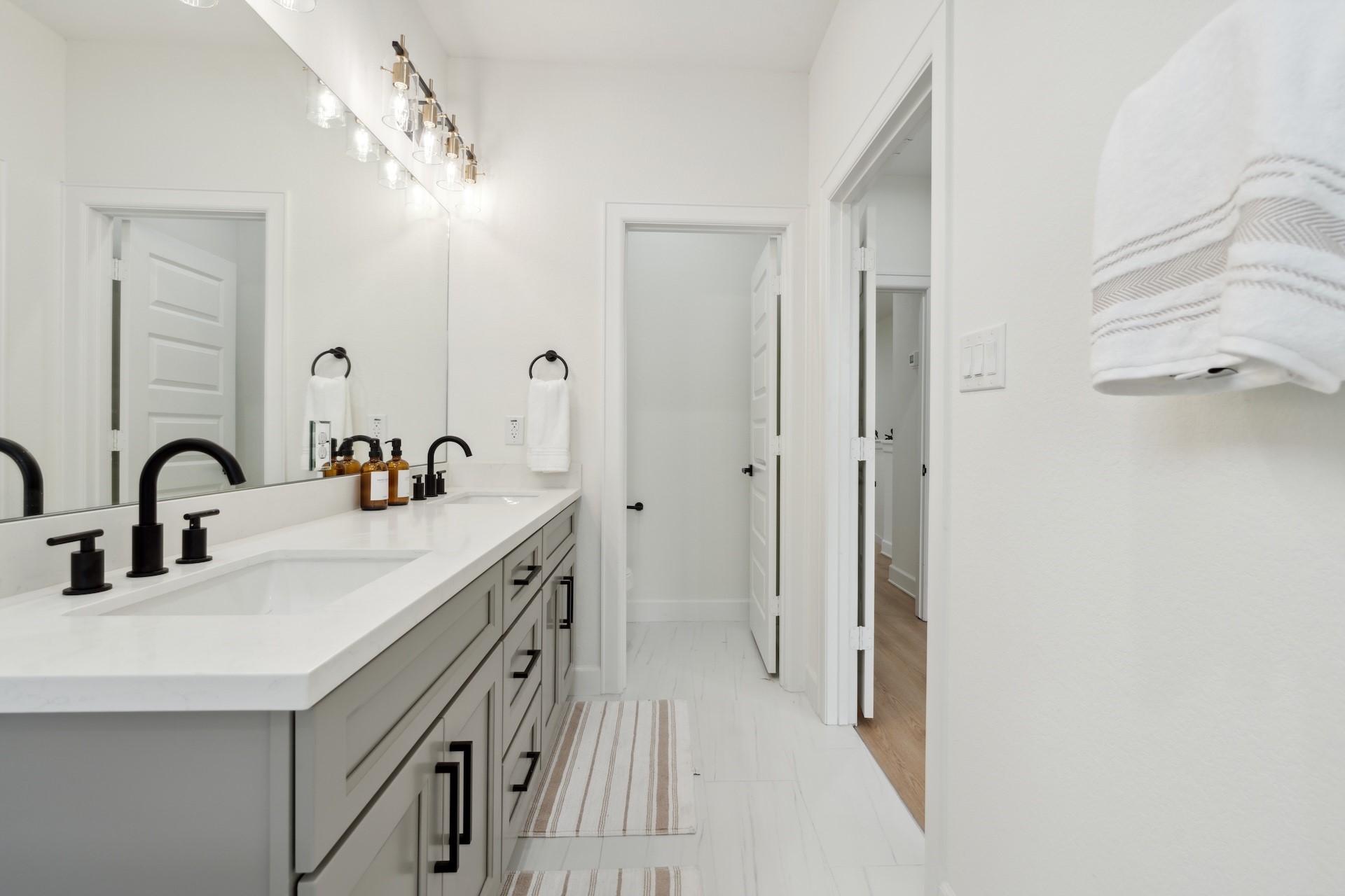 6408 Foster Street Houston, TX 77021 - Photo 29 of 39 Primary ensuite perspective — extended quartz counter with double sinks, matte black hardware accents, bright vanity lighting, and tiled floor throughout.