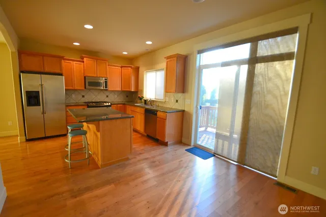 a kitchen with stainless steel appliances granite countertop wooden floors and sink