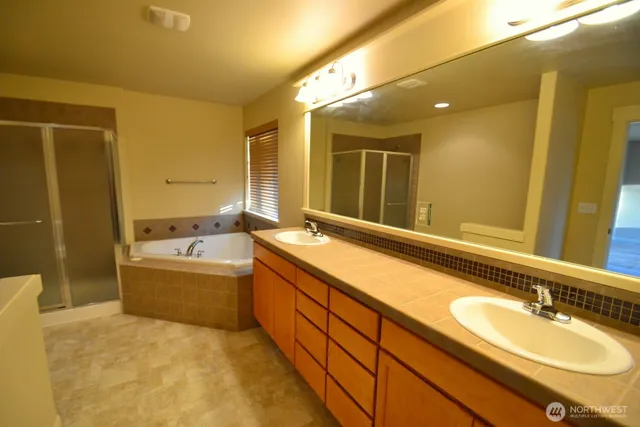 a bathroom with a granite countertop sink and a bathtub