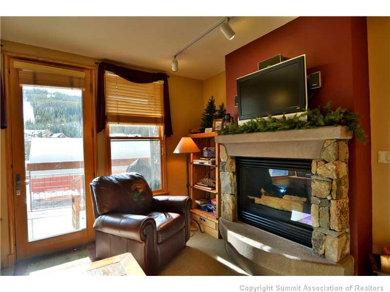 195 River Run Road, Unit 8043 Keystone, CO 80435 - Photo 6 of 25 a living room with a fireplace a flat screen tv and a fireplace