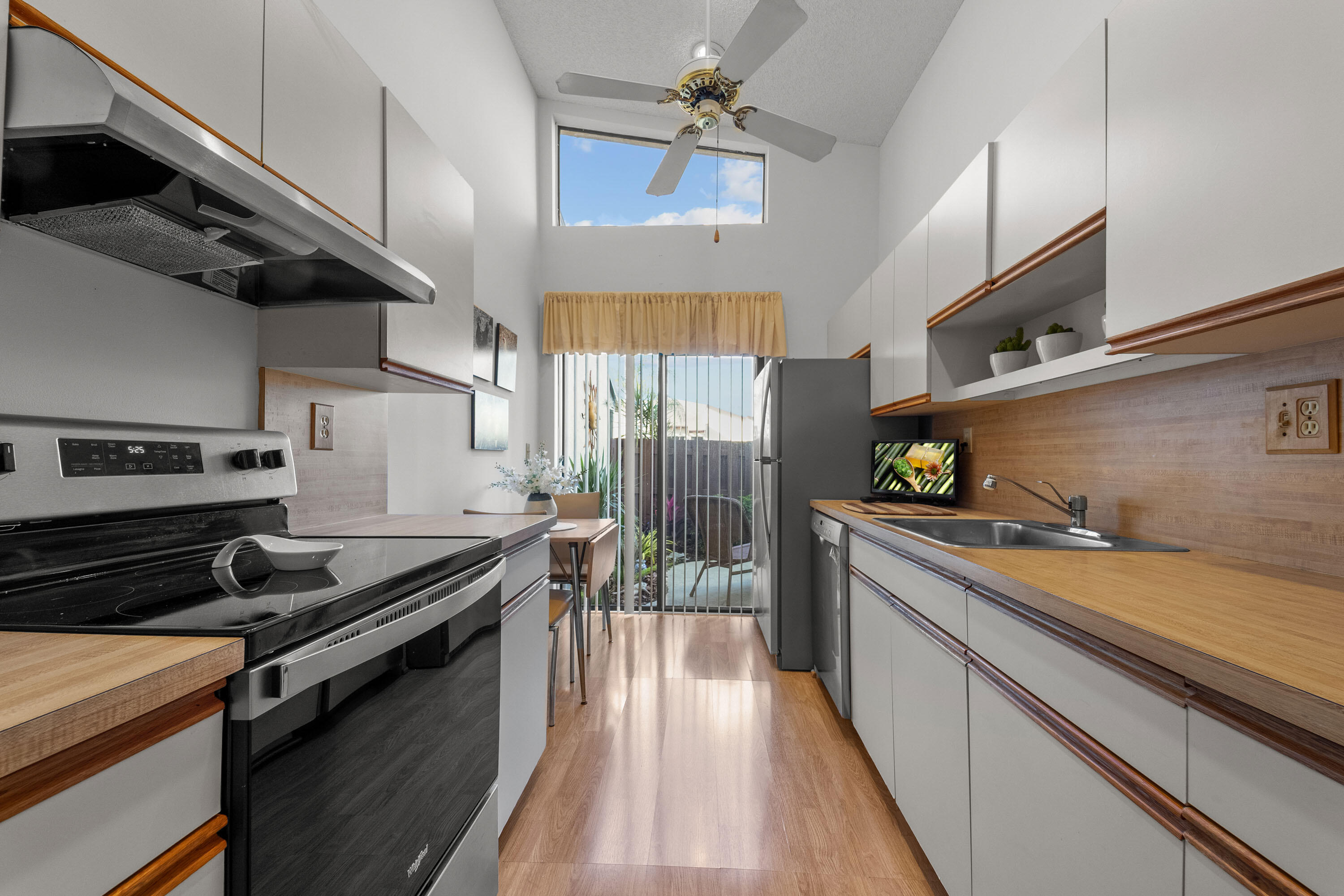 5080 Nesting Way, Unit A Delray Beach, FL 33484 - Photo 24 of 37 a kitchen with stainless steel appliances granite countertop a stove a sink and a microwave