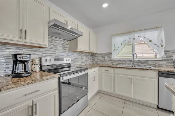 a kitchen with granite countertop cabinets stainless steel appliances and a counter space