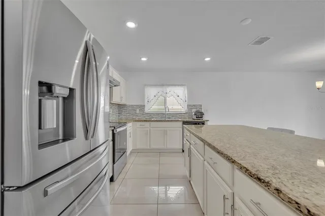 a kitchen with granite countertop white cabinets and white appliances
