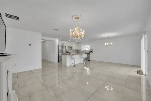 a view of a kitchen with granite countertop a sink and a chandelier