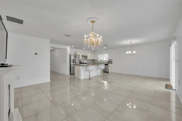 a view of a kitchen with granite countertop a sink and a chandelier