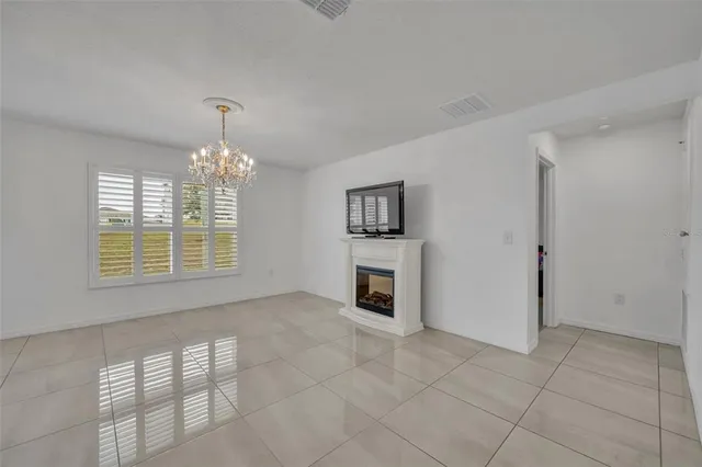an empty room with chandelier and windows